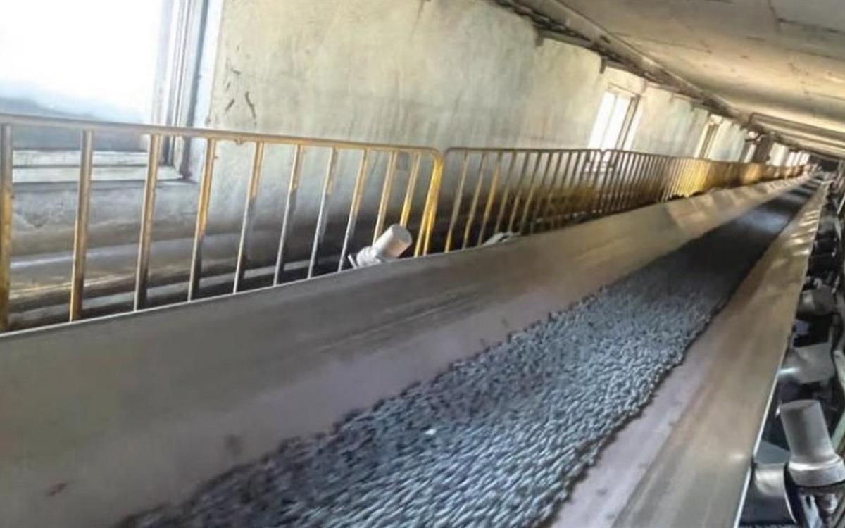 Enclosed conveyor gallery with a belt carrying grey material